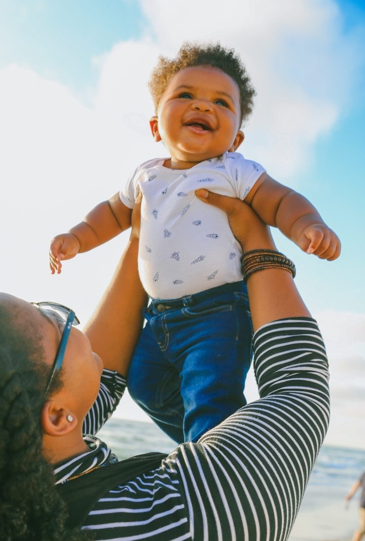 woman in black and white striped long sleeve shirt carrying baby in blue onesie